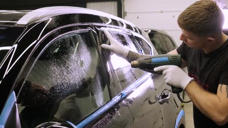 man covering car with vinyl polyurethane tape. films for the car. sticker protective film on the car