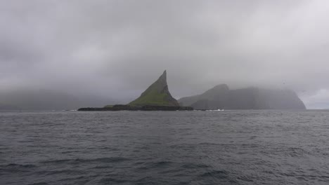 Punto-De-Vista-Del-Barco-Acercándose-A-Tindholmur-En-Un-Día-Nublado-Y-De-Mal-Humor,-Islas-Feroe