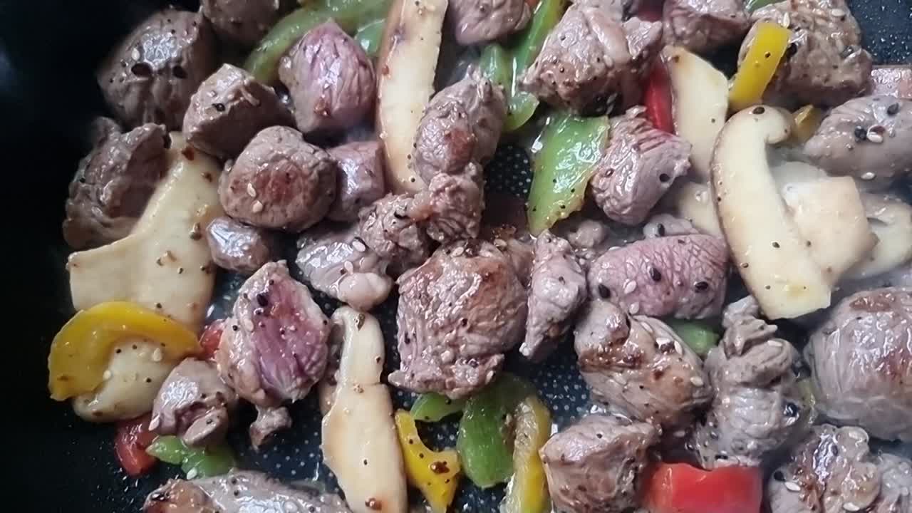 Delicioso cordeiro em cubos fumegante com vegetais chiando em uma frigideira sobre um fogão quente.