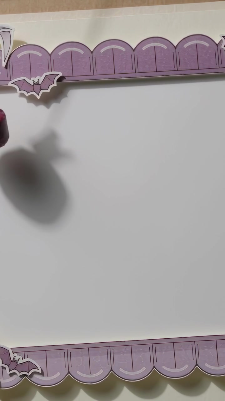 Video verticale: posizionamento di un tubo rosso, mano fuori campo che proietta un'ombra su un foglio bianco, bordo viola, pipistrelli
