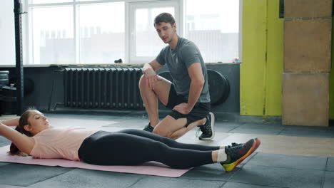 woman doing crunches with personal trainer
