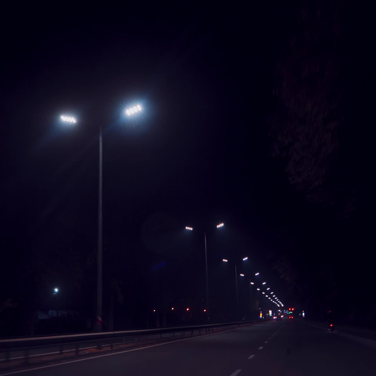 driving by car at night between illuminated lanterns aruond. Highway at night