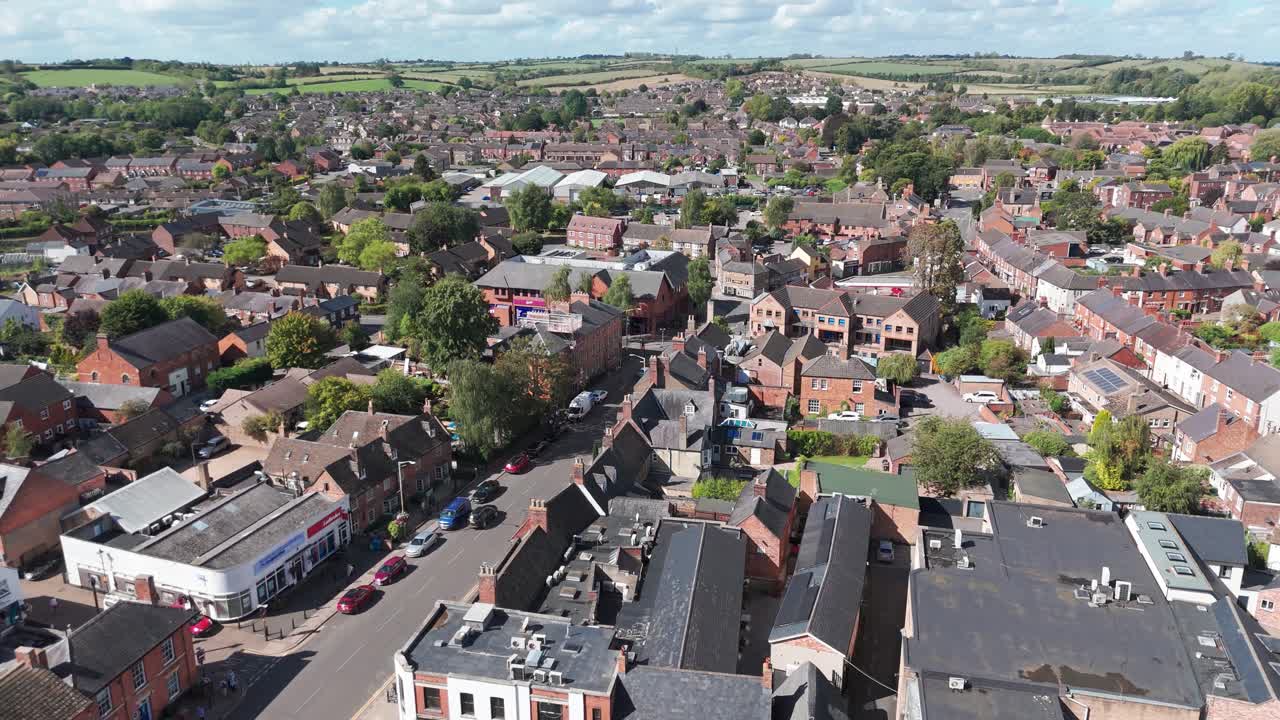 Residential, housing areas blend with a central commercial, business, retail district, all surrounded by green, lush countryside hills and slopes