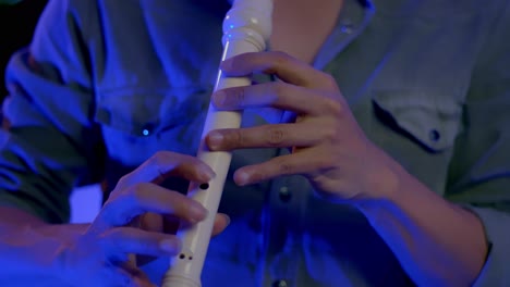 close up shot of musician's hands playing recorder