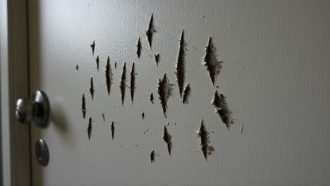 damaged door close-up: a detailed view of surface scratches and indentations on a white door highlighting wear and tear over time