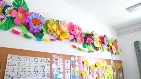 colorful paper flowers decorate a bright classroom wall in an elementary school