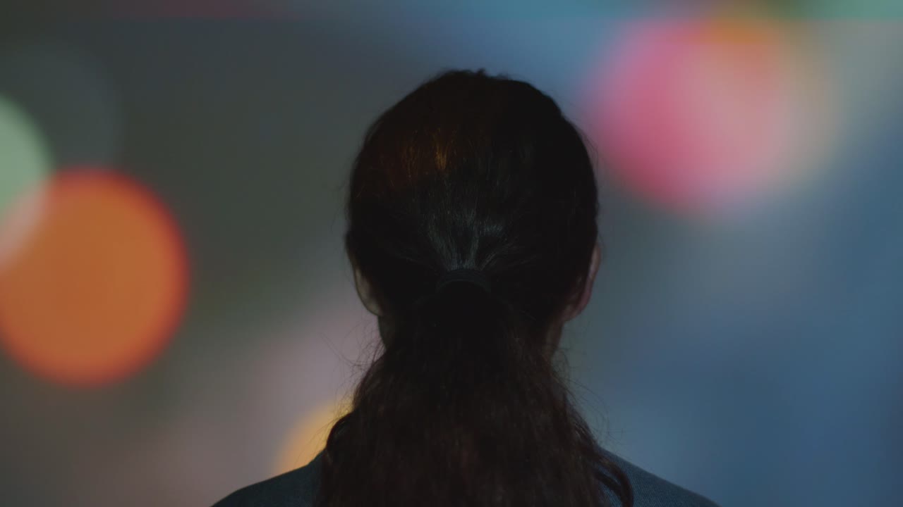 벽에 모양과 패턴을 투사하는 몰입 예술 전시회를 방문하는 여성