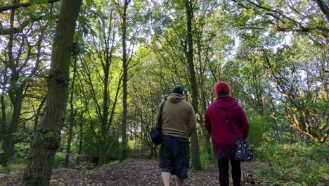 loving couple walking pet dog along autumn woodland path exercising in wilderness healthy lifestyle