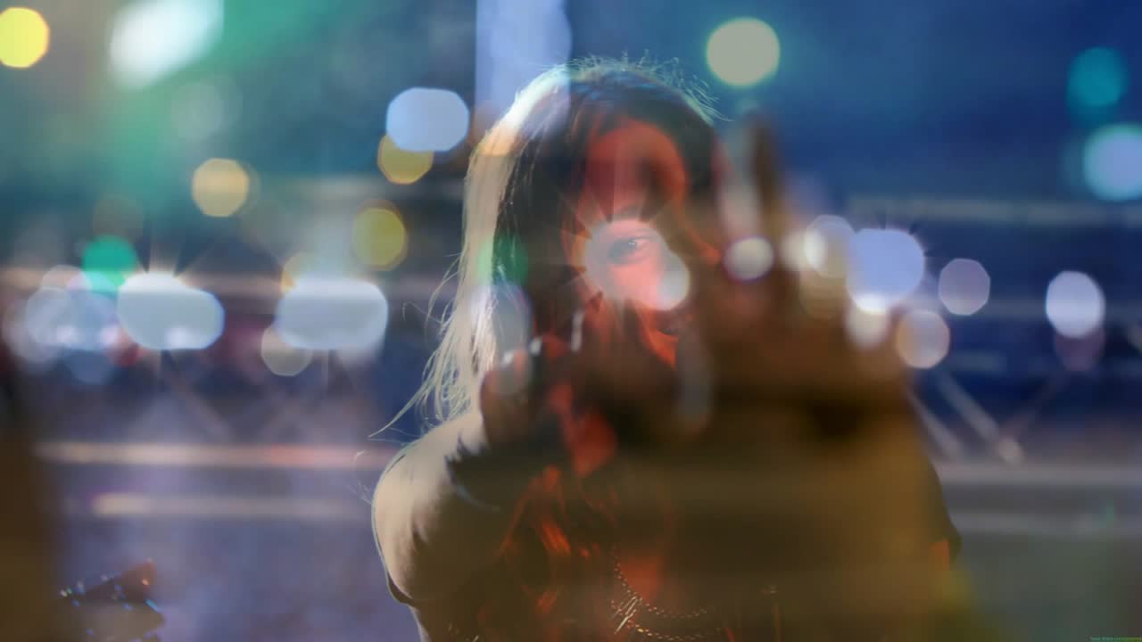 Vocalist on music cue, singing into mic and pointing to engage crowd, bokeh revealing singer