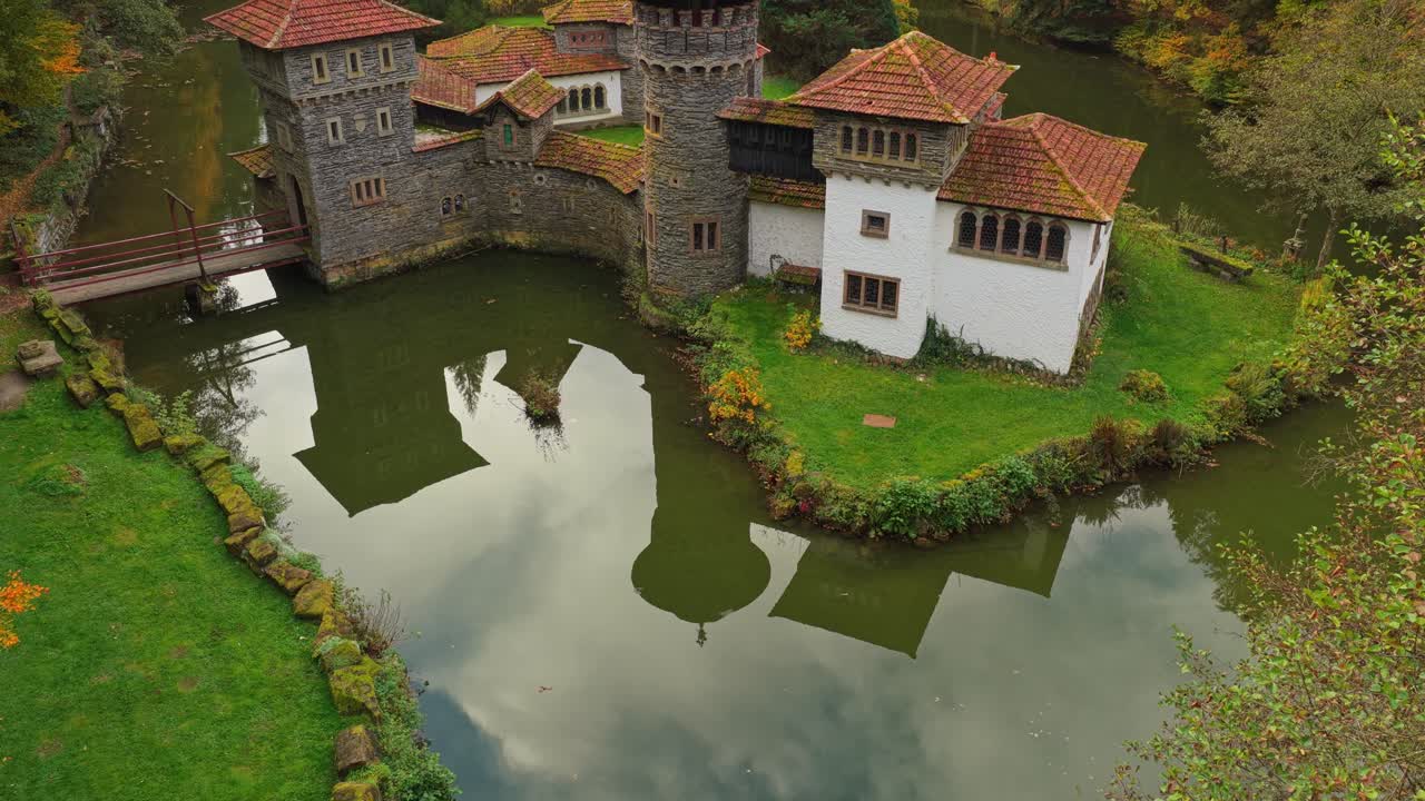 Livlige efterårsfarver omgiver Chateau de Turelbaach i drone topbillede.