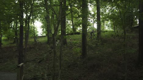 Weite-Aufnahme-Von-Zwei-Radfahrern,-Die-Durch-Den-Wald-Fahren