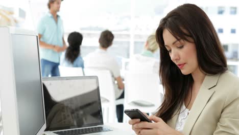 Mujer-Trabajando-En-Su-Escritorio-Enviando-Mensajes-De-Texto-Por-Teléfono