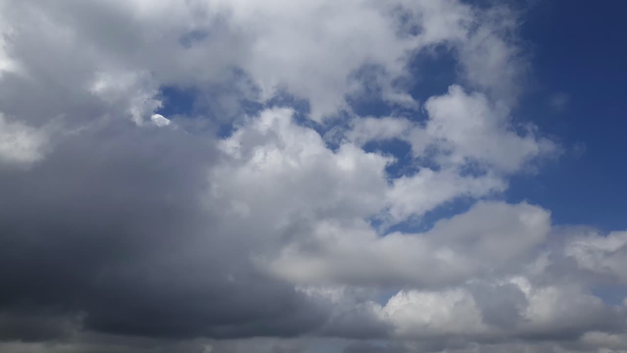 cielo azul de verano con densas nubes de lluvia gruesas moviéndose a través de los cielos
