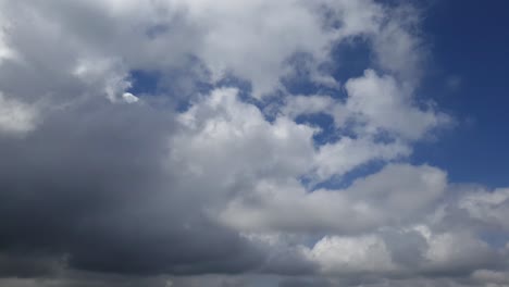 Blauer-Sommerhimmel-Mit-Dichten,-Dicken-Regenwolken,-Die-Sich-über-Den-Himmel-Bewegen