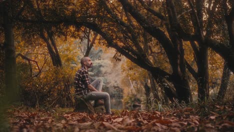 man sits by river or lake in portugal, feeling calm and introspective. he admires trees and nature. warm and relaxing clip.