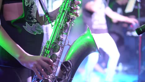 unrecognizable musician is playing on saxophone in concert. close-up on fingers pressing the keys of the instrument. slow motion