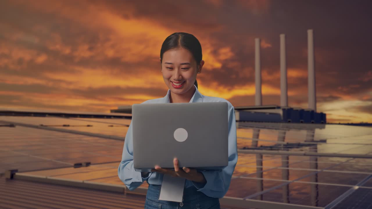 Asian Female With Her Laptop, Inspecting Solar Panels on Rooftop at Sunset, Work Continuously