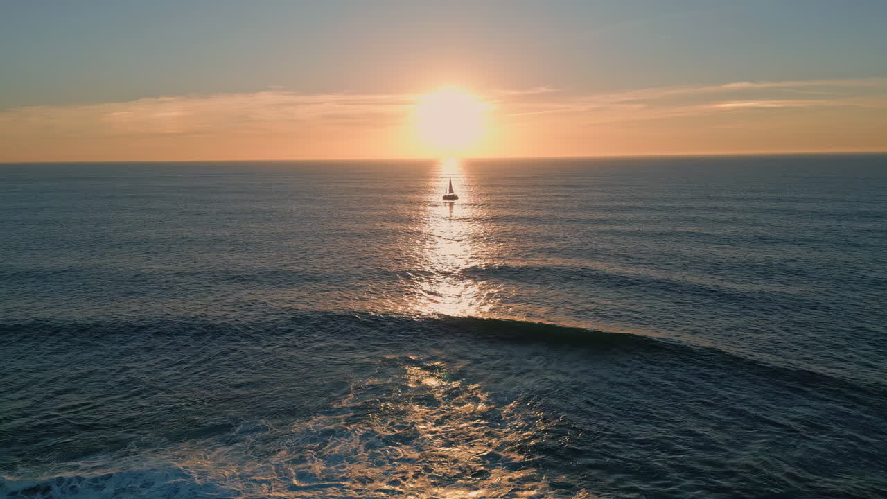 Silhouette sailing boat sunset aerial view. Sun reflecting in beautiful ocean