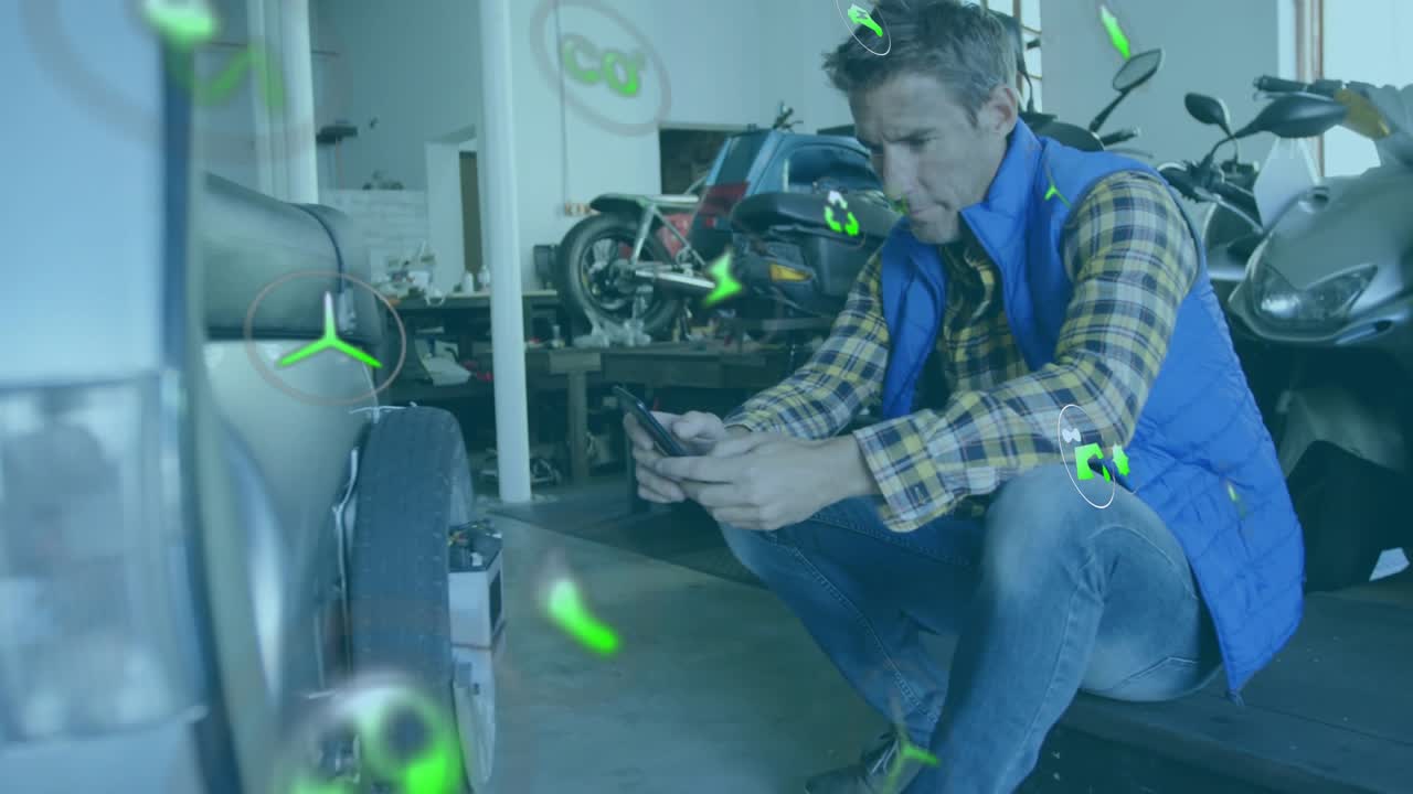 Tech crouching next to car wheel, tapping phone and causing diagnostic icons around hands and wheel