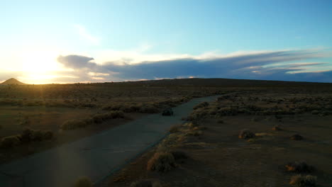 seguimiento aéreo de un vehículo todoterreno en el desierto de mojave durante una puesta de sol dorada
