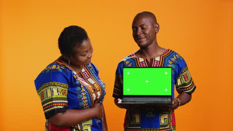 african american partners holding laptop with greenscreen