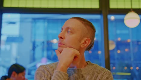 hombre blanco caucásico comprar modelo de niño con ojos azules y cabello brillante está sentado en un café, restaurante y esperando, pensando, reflexionando