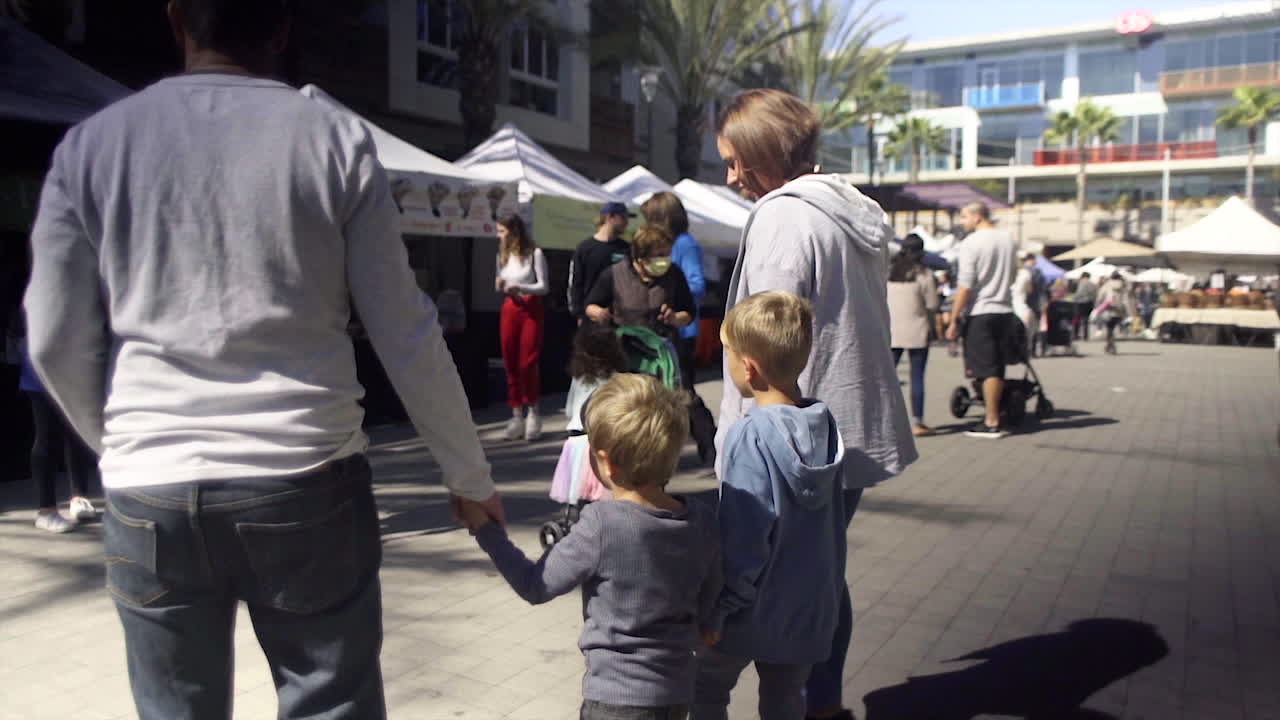 A family walks through an outdoor market