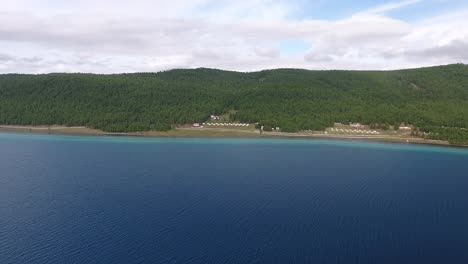 drone aéreo disparado moviéndose hacia adelante yurts a lo largo del lago khuvsgul en mongolia