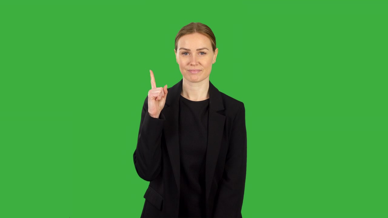 A business woman in black pointing up with finger on green screen background