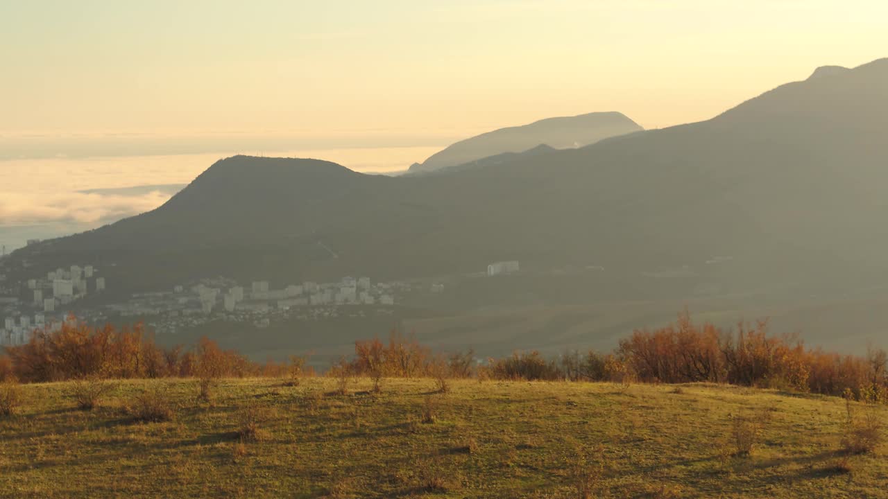 계곡에 있는 도시와 함께 해가 뜨고 해가 지는 산의 풍경