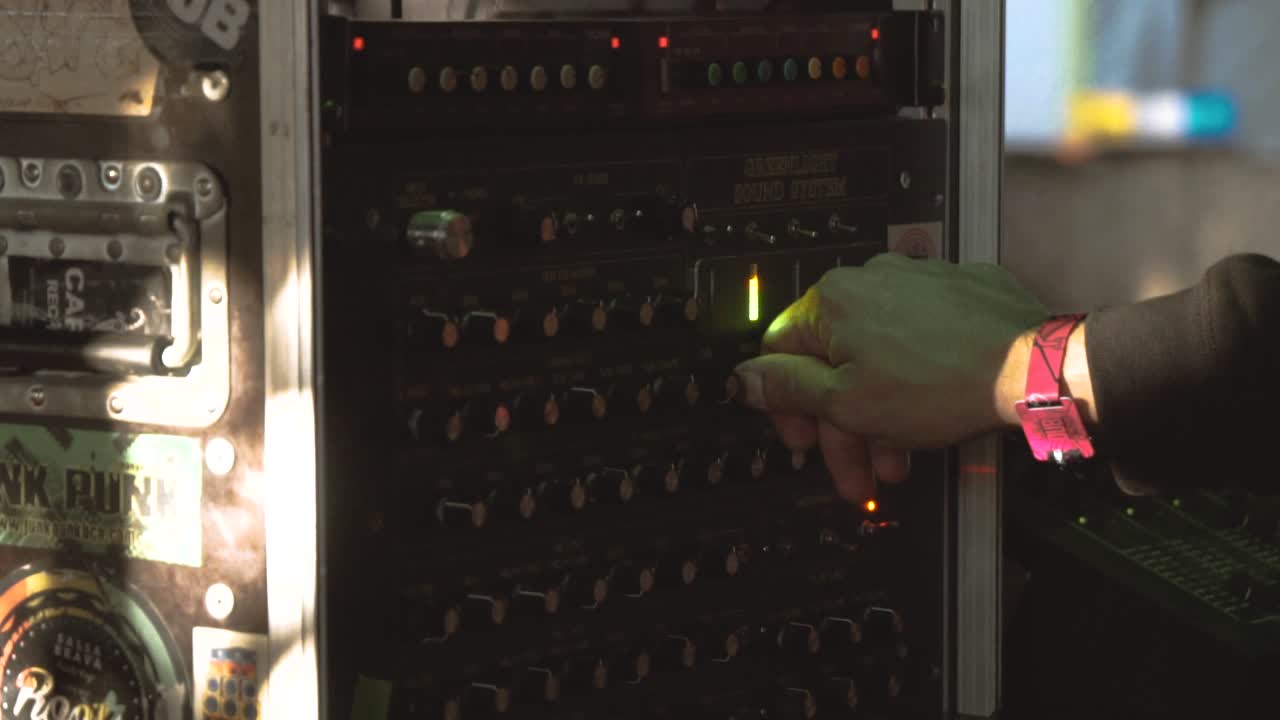 toma en cámara lenta de una mano usando un controlador de sistema de sonido en una fiesta de regge