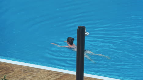 una joven sensual relajándose en la piscina.