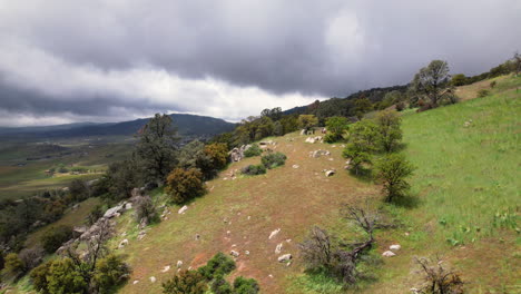 Drone-footage-of-rolling-hills-and-grasslands-near-Tehachapi,-California-with-dramatic-cloudy-skies