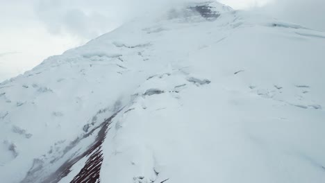 Filmische-Luftaufnahme-Des-Gletschers-Und-Der-Weißen-Gefrorenen-Eiskappen-Am-Berghang