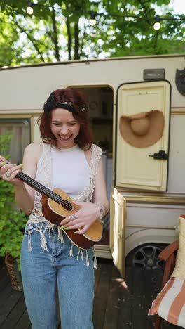 happy woman playing ukulele outdoors