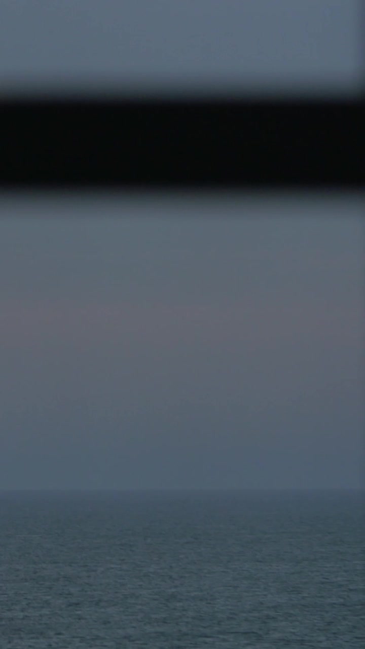 Looking at evening seascape through the window
