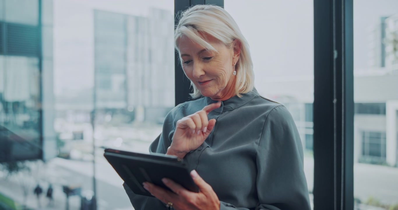 Mature Businesswoman Using Tablet in Modern Office