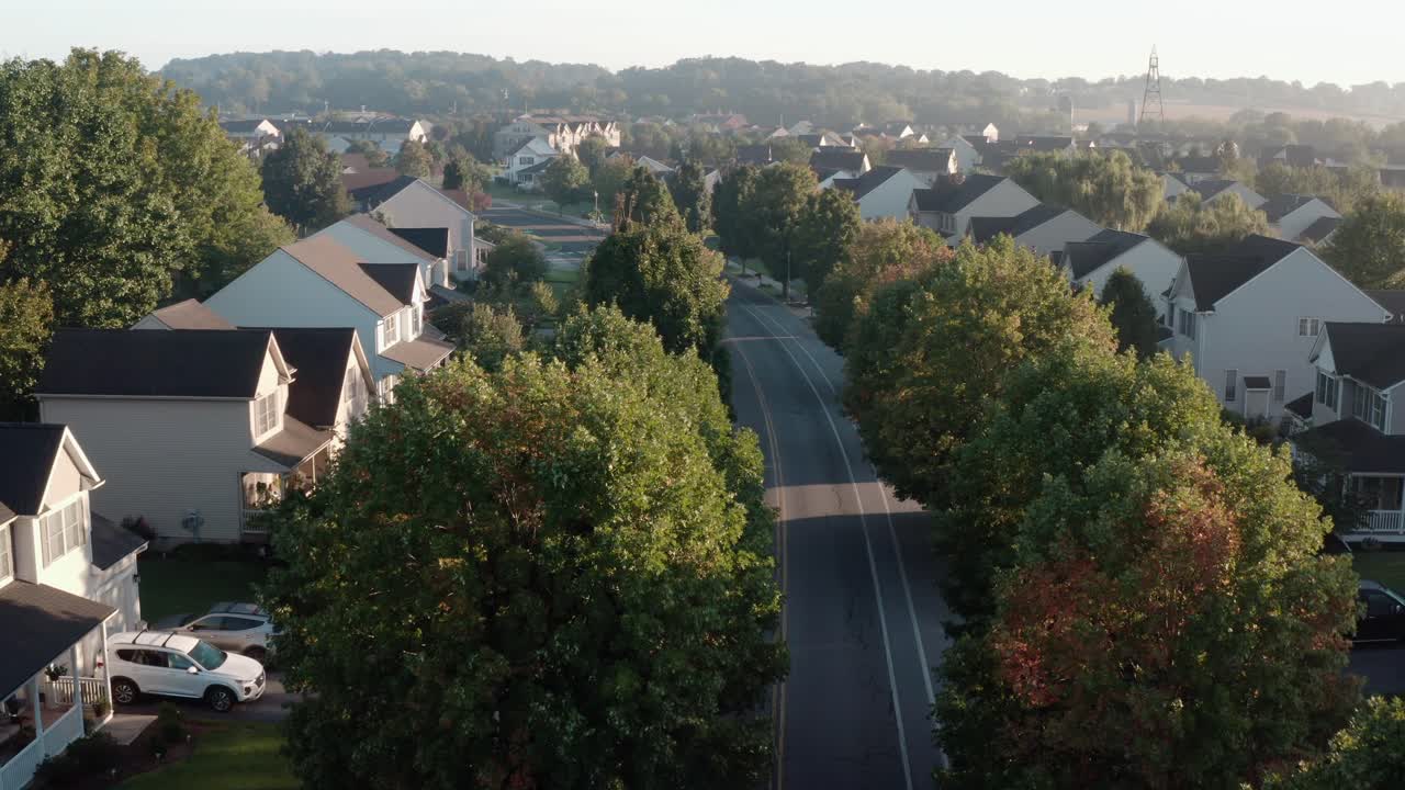 Aerial of cars on street through American suburb
