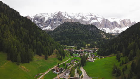 Drone footage of a rugged rocky mountain peak surrounded by snow patches and dramatic cliffs in the Dolomites, Italy