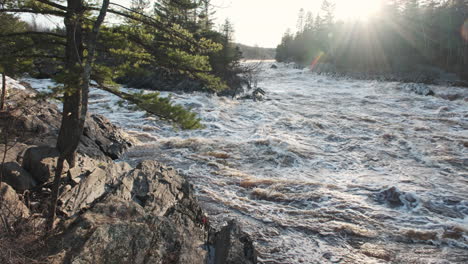 sunlight beams illuminating a swollen river from spring snowmelt in northern minnesota