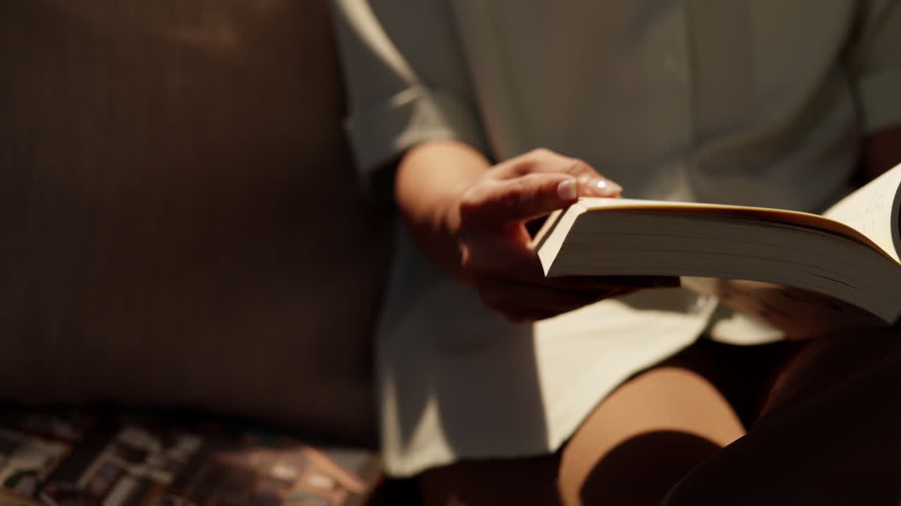 A person enjoys reading a book in a cozy living room embracing ...