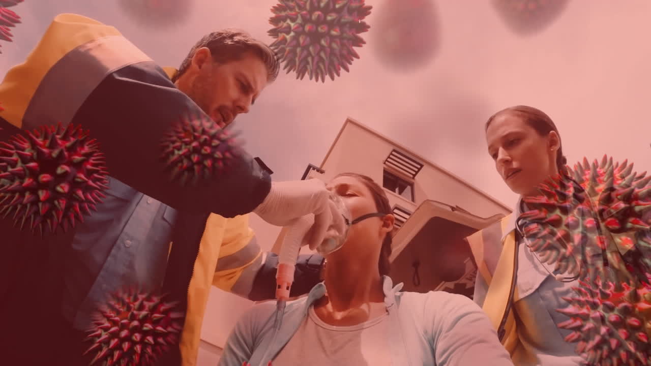 코로나19 세포가 배경에 있는 여성에게 산소 마스크를 착용하는 구급대원들에게 퍼지고 있습니다.