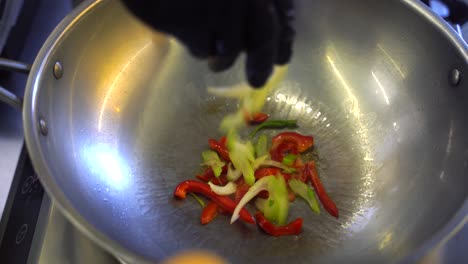 stir-frying vegetables in a wok