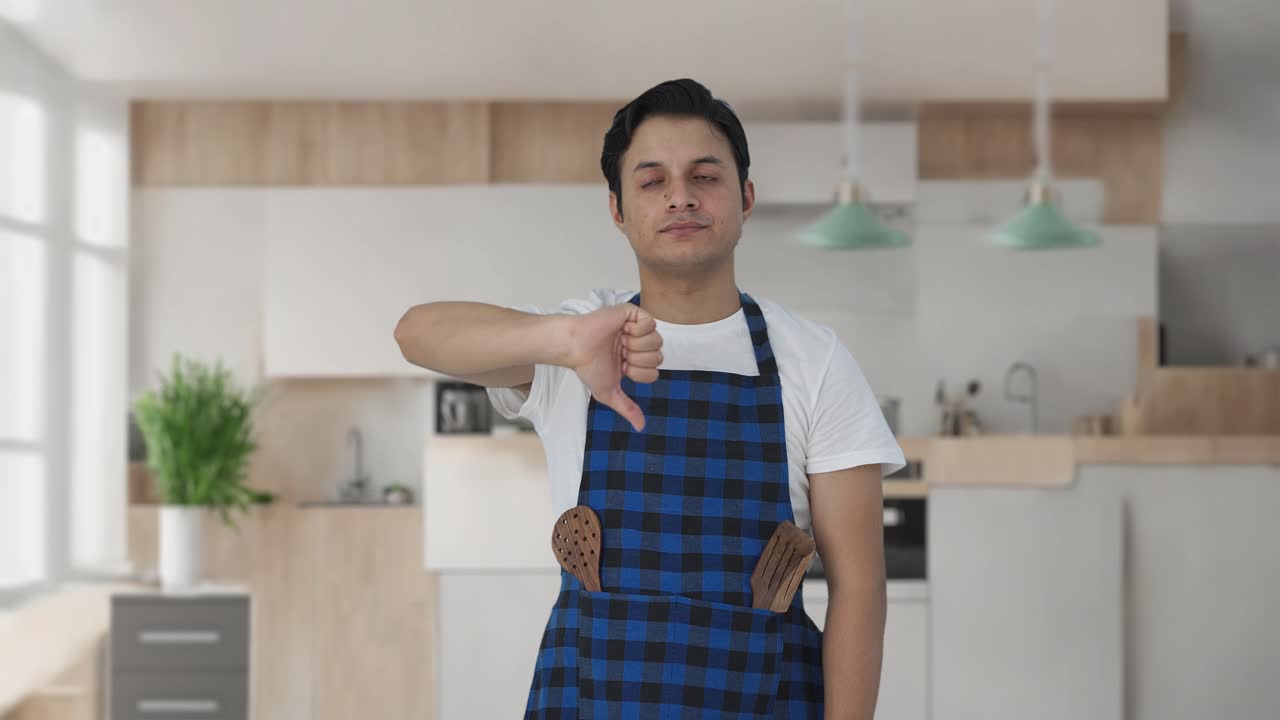 cocinero indio decepcionado mostrando los pulgares hacia abajo