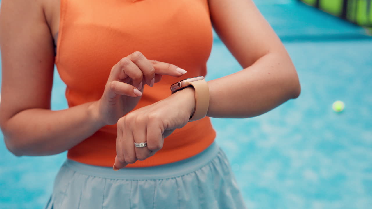 Primo piano di una donna che tocca lo schermo di uno smartwatch all'aperto.