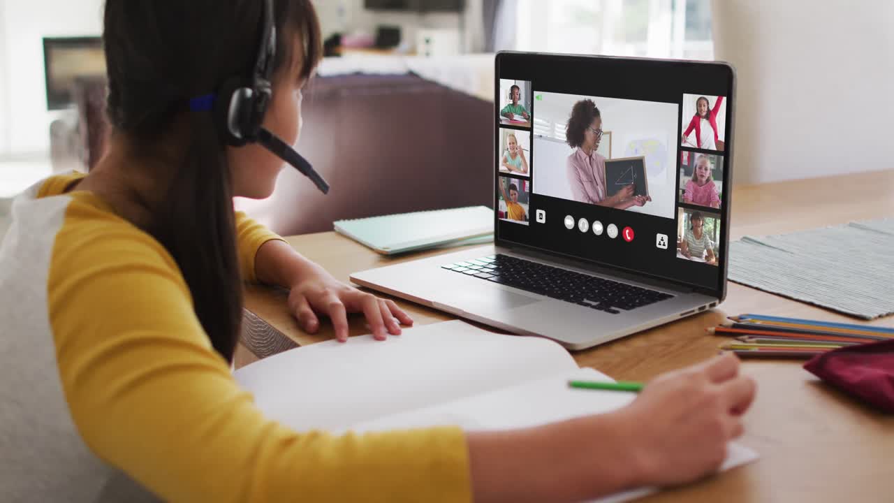 Schoolgirl using laptop for online lesson at home, with diverse teacher and class on screen