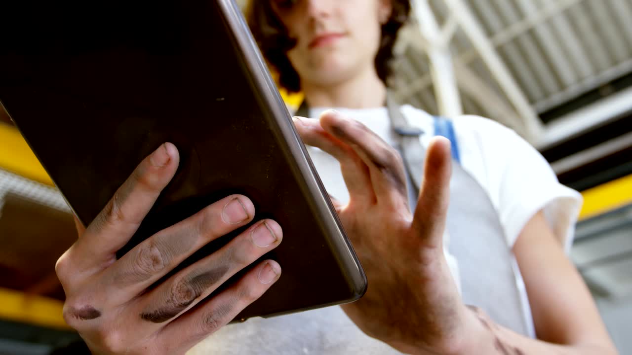 soldadora que utiliza una tableta digital en el taller 4k