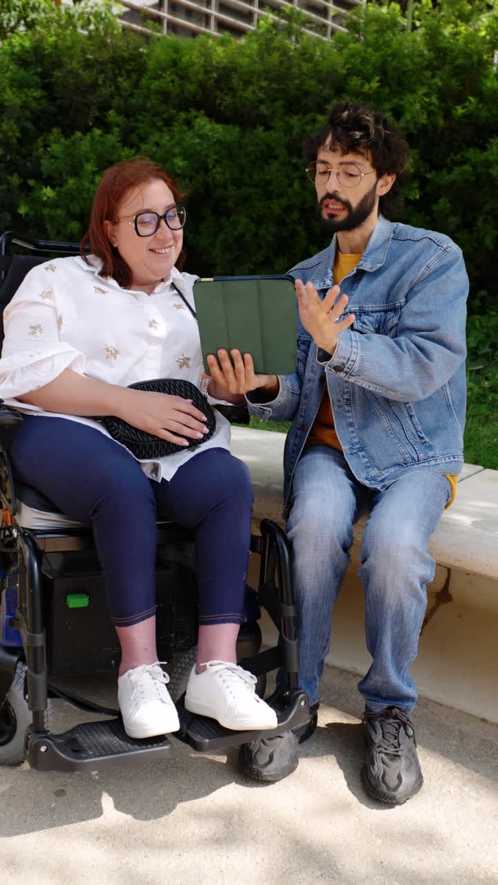 Two people using a tablet outdoors