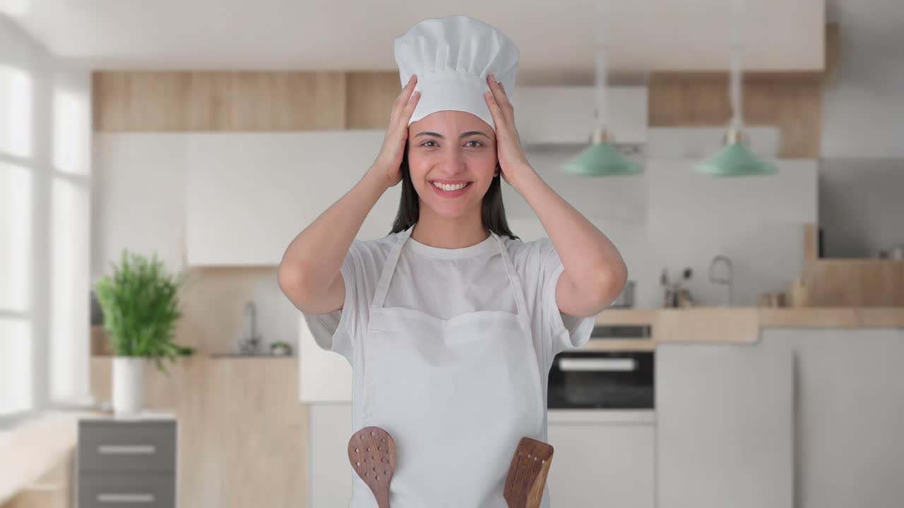 Felice cuoca professionista indiana con cappello