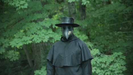 Plague-doctor-standing-in-forest-zoom-in